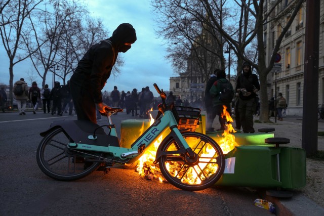 3/6. Un manifestant met un vélo sur un feu d'ordures. © Michel Stoupak. Lun 20.03.2023, 19h03m46.