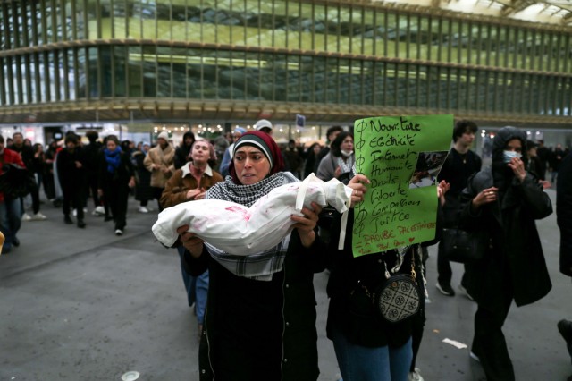 15/18. Une femme porte un tissu représentant un enfant mort. © Michel Stoupak. Sam 28.10.2023, 15h16m03.