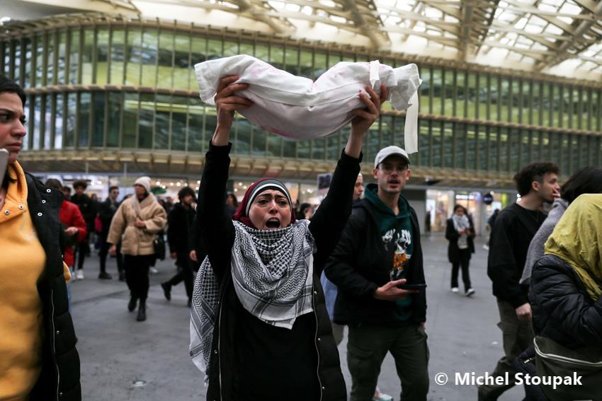1/18. Une femme porte un tissu représentant un enfant mort. © Michel Stoupak. Sam 28.10.2023, 15h16m07.